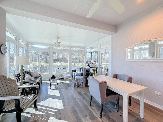 sunroom / solarium with beamed ceiling and ceiling fan