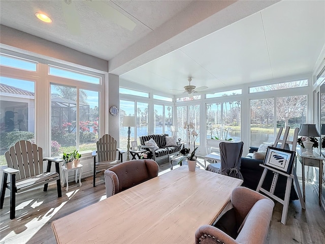 sunroom / solarium with a water view and ceiling fan