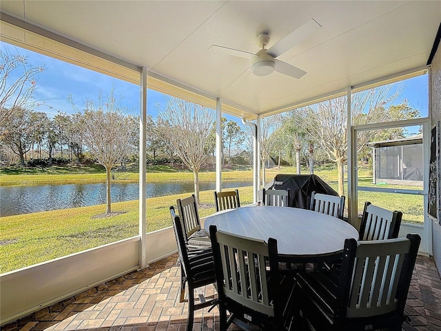 sunroom / solarium with a water view and ceiling fan