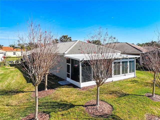 rear view of house with a sunroom and a yard