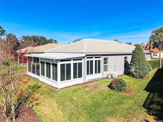 back of property with a yard and a sunroom