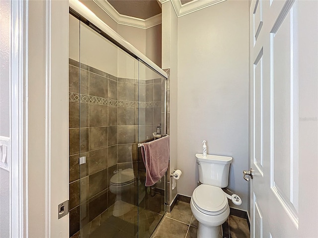 full bath featuring tile patterned flooring, toilet, baseboards, ornamental molding, and a stall shower