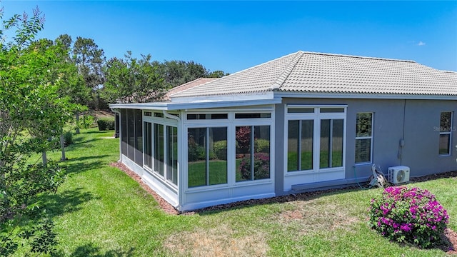 15856 Cobble Mill Dr, Wimauma, FL 33598 - rear view of house featuring a sunroom, a lawn, and a tile roof
