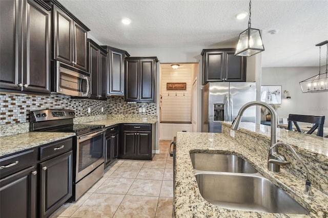 kitchen featuring appliances with stainless steel finishes, sink, decorative backsplash, and decorative light fixtures