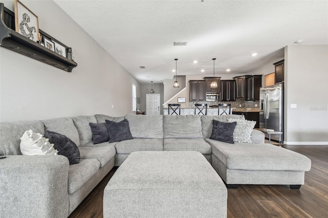 living room featuring dark hardwood / wood-style floors and a textured ceiling