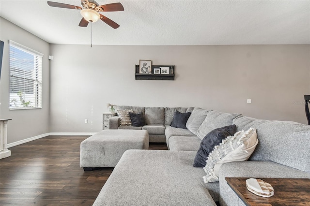 living room with a textured ceiling, dark wood-type flooring, and ceiling fan