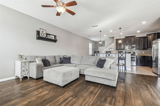 living room with dark hardwood / wood-style flooring and ceiling fan