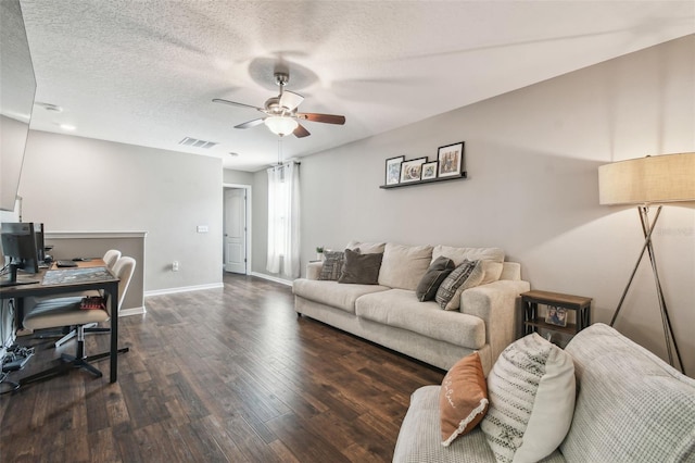 living room with ceiling fan, dark hardwood / wood-style floors, and a textured ceiling