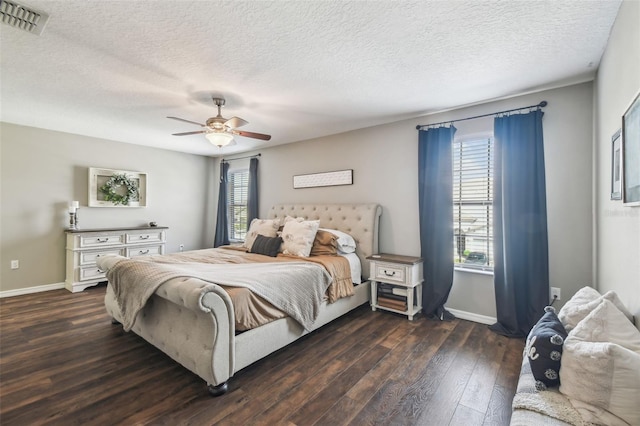 bedroom with ceiling fan, dark hardwood / wood-style floors, and a textured ceiling