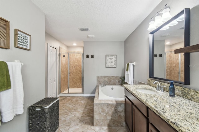 bathroom featuring vanity, shower with separate bathtub, and a textured ceiling