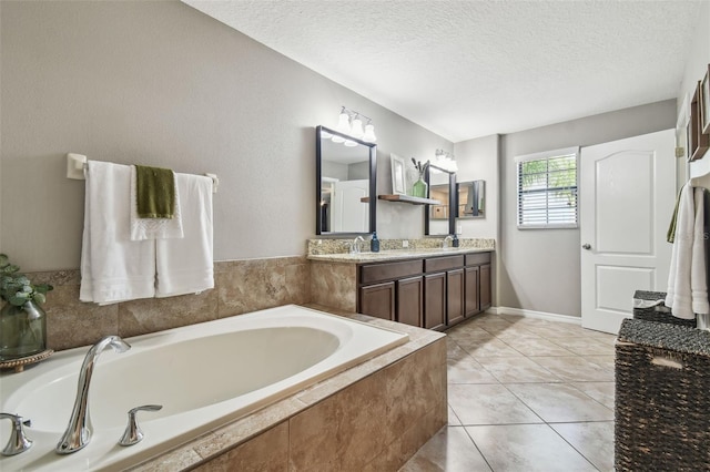 bathroom with vanity, tiled tub, tile patterned floors, and a textured ceiling