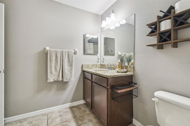 bathroom with vanity, toilet, and tile patterned flooring