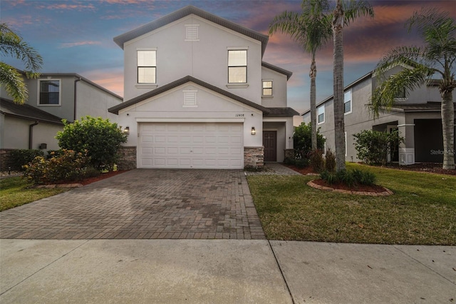 view of front facade with a garage and a lawn