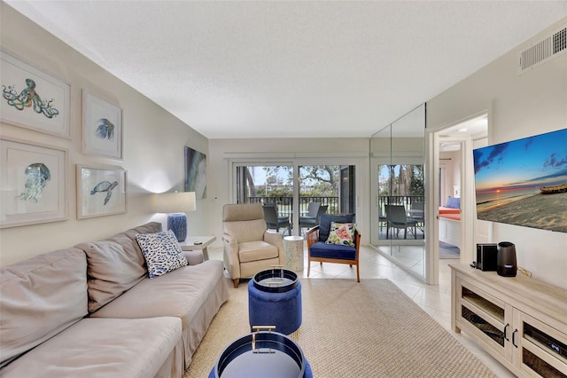 tiled living room featuring a textured ceiling