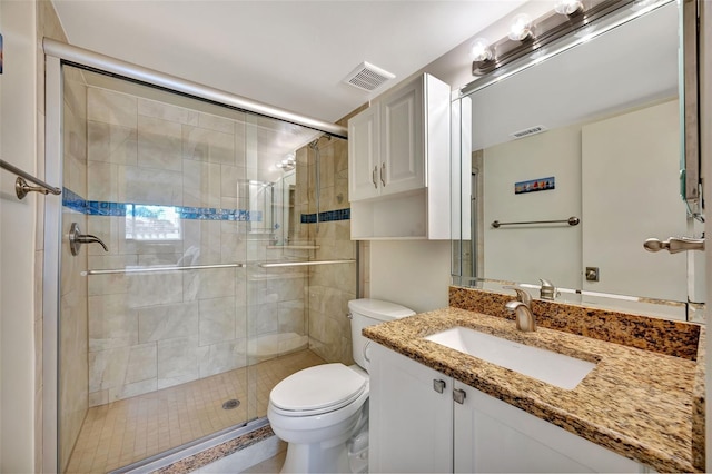 bathroom with vanity, toilet, and a shower with door