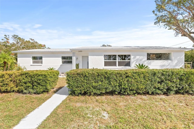 single story home featuring a front lawn