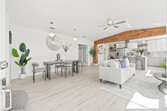 living room featuring ceiling fan, lofted ceiling, and light wood-type flooring