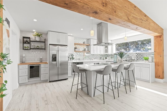 kitchen featuring pendant lighting, white cabinetry, island exhaust hood, beverage cooler, and stainless steel built in fridge