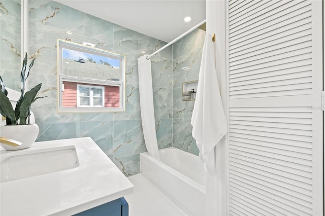 bathroom featuring tile walls, vanity, and shower / bath combo