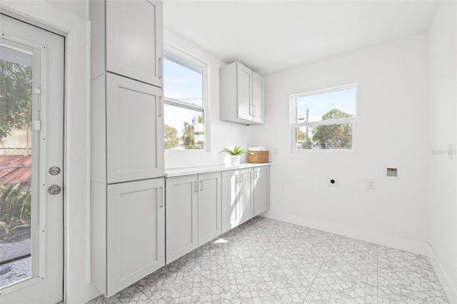 washroom with cabinets, a healthy amount of sunlight, hookup for an electric dryer, and hookup for a washing machine