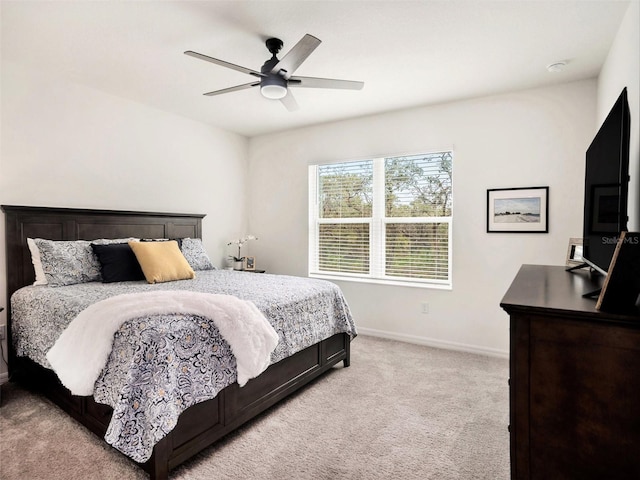 bedroom featuring baseboards, a ceiling fan, and light colored carpet