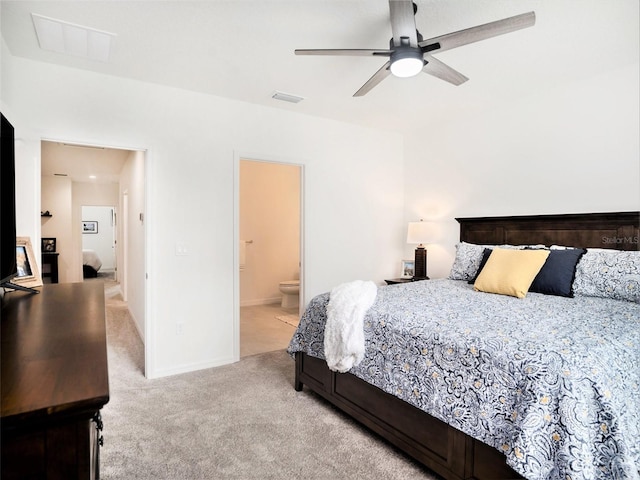 bedroom with ceiling fan, ensuite bathroom, light carpet, visible vents, and baseboards