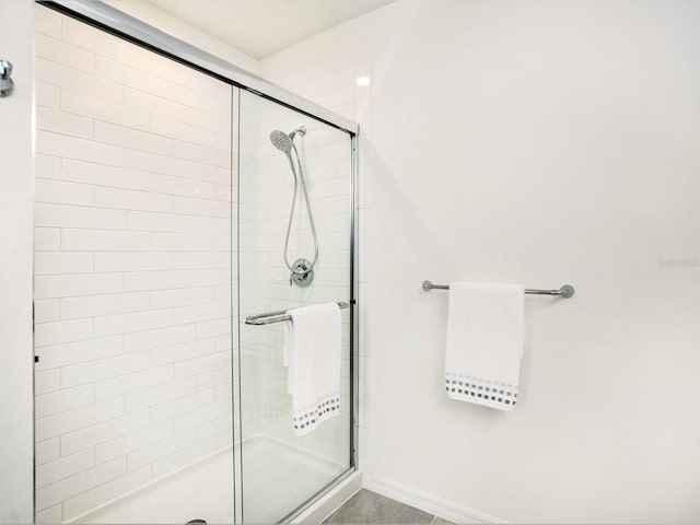 bathroom with a stall shower and baseboards