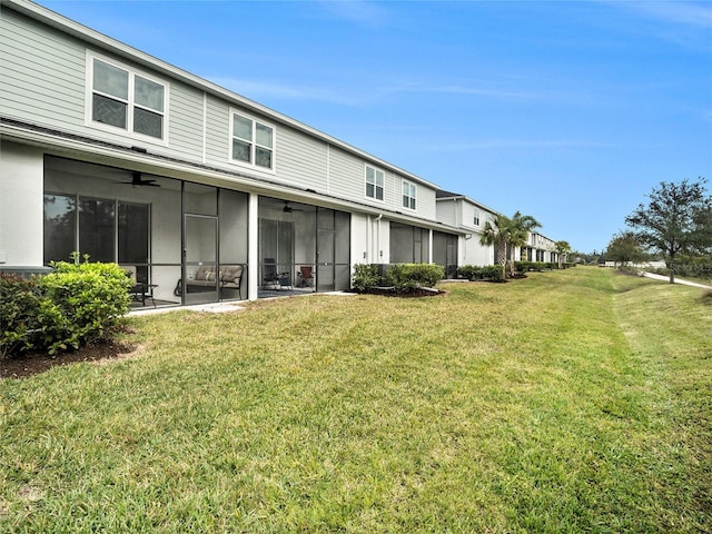 back of property with a yard and a sunroom