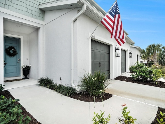 exterior space with a garage, driveway, and stucco siding