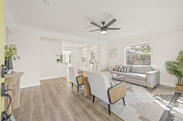 living room featuring ceiling fan and light wood-type flooring