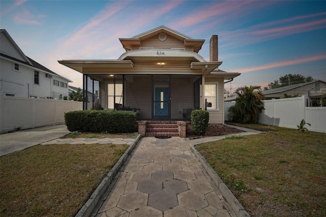 view of front of house with a lawn and a porch