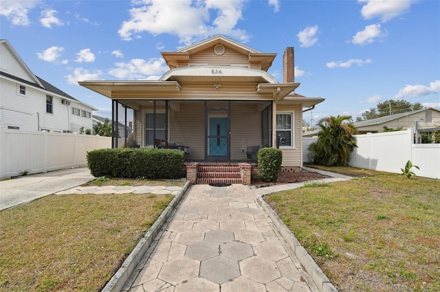 view of front of house with covered porch and a front lawn