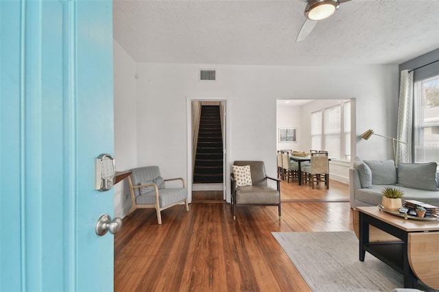 living room with dark wood-type flooring and a textured ceiling