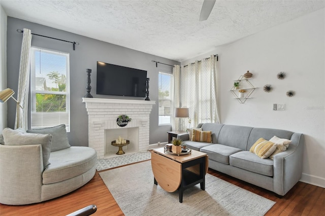 living room with hardwood / wood-style flooring, a fireplace, and a textured ceiling