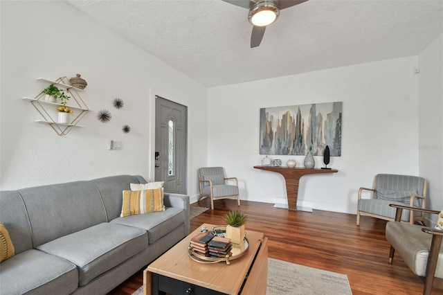 living room with ceiling fan, dark hardwood / wood-style flooring, and a textured ceiling