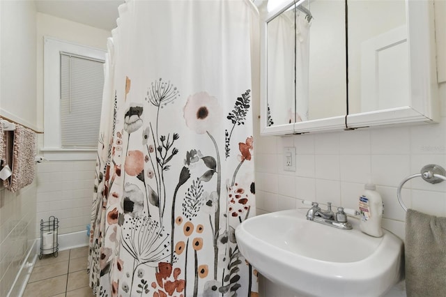 bathroom with a shower with curtain, tile patterned flooring, sink, and tile walls