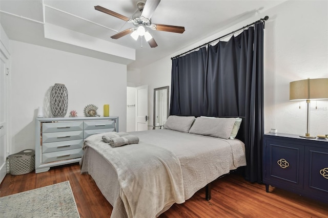 bedroom with dark hardwood / wood-style flooring and ceiling fan