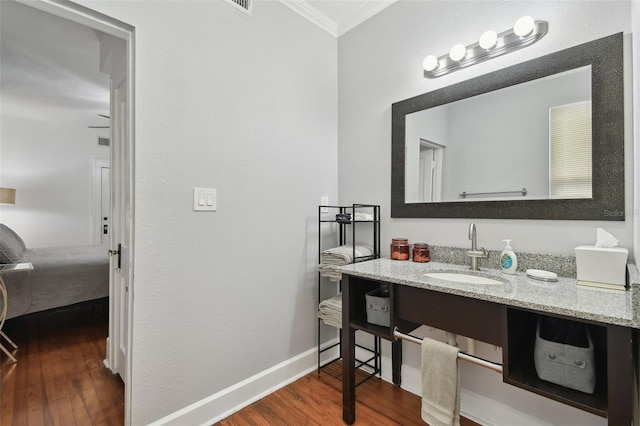 bathroom with ornamental molding, wood-type flooring, and vanity