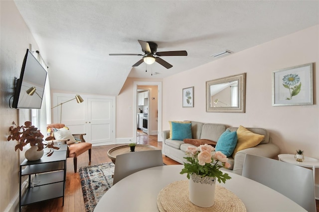 living room with ceiling fan, hardwood / wood-style floors, and a textured ceiling