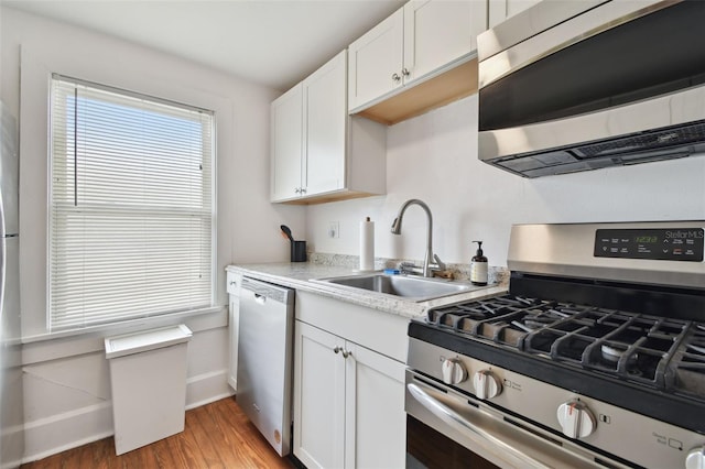 kitchen featuring white cabinetry, appliances with stainless steel finishes, sink, and light hardwood / wood-style floors