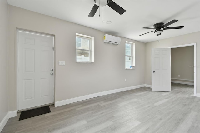 interior space featuring ceiling fan, a wall unit AC, and light hardwood / wood-style flooring