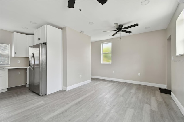 kitchen featuring white cabinetry, ceiling fan, stainless steel fridge, and light hardwood / wood-style flooring