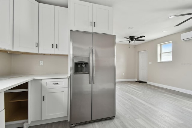 kitchen featuring stainless steel fridge with ice dispenser, a wall unit AC, white cabinets, and ceiling fan