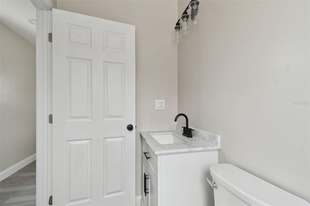 bathroom with vanity, hardwood / wood-style flooring, and toilet