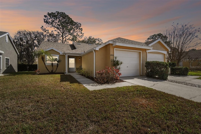 ranch-style house featuring a garage and a lawn