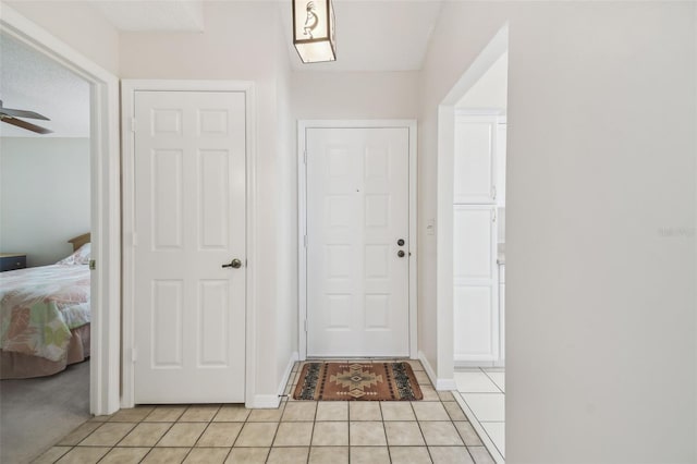 doorway featuring light tile patterned floors and ceiling fan