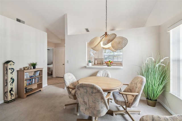 dining room with light colored carpet and vaulted ceiling