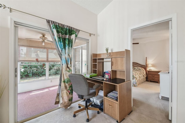 carpeted home office featuring ceiling fan