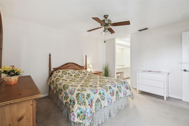 carpeted bedroom with ceiling fan and ensuite bath