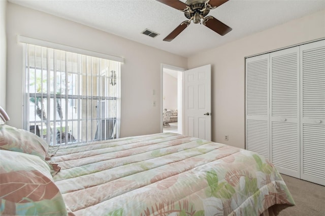 bedroom featuring ceiling fan, carpet, a textured ceiling, and a closet